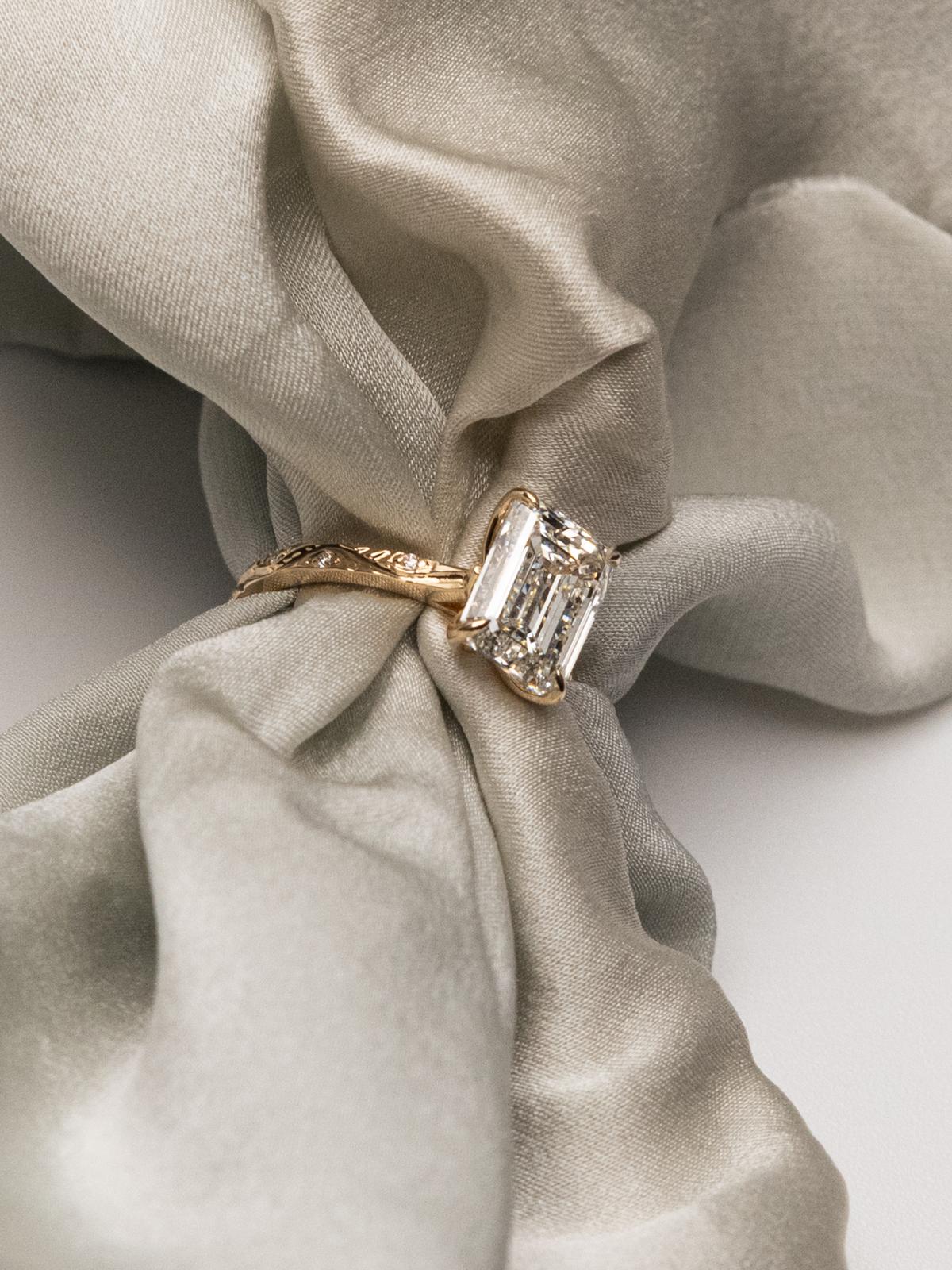 custom emerald cut diamond engagement ring in 18k yellow gold with engraved band — bespoke fine jewelry by Kalakari